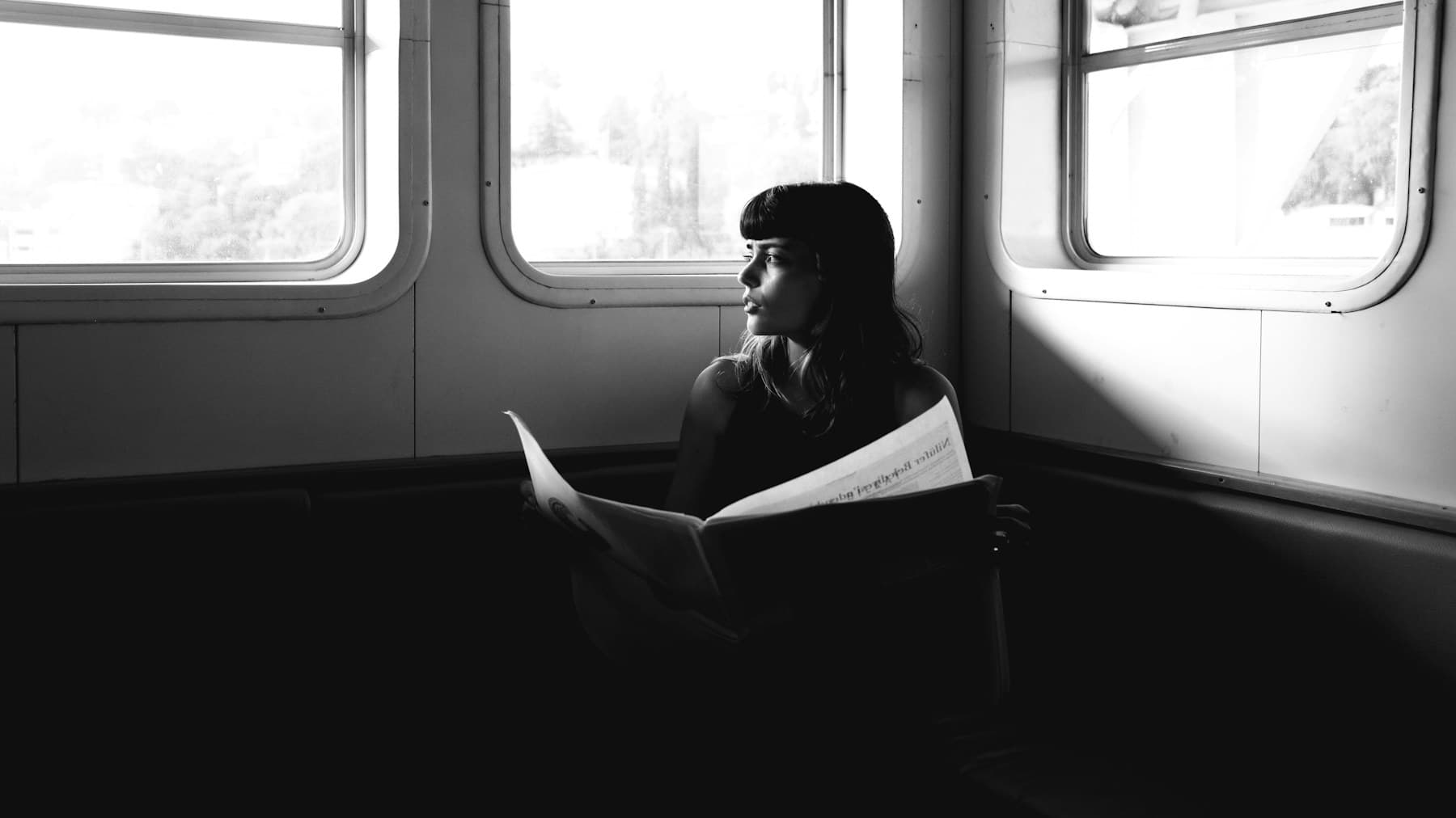 A passenger reading by the window during a train journey